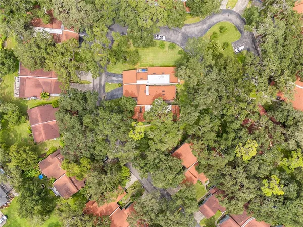a aerial view of a house with a yard and a large tree
