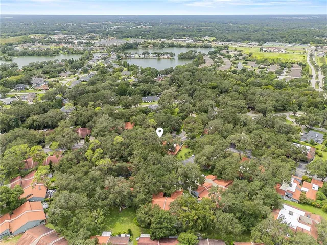 an aerial view of residential houses with outdoor space and trees