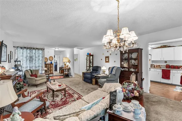 a living room with fireplace furniture and a chandelier
