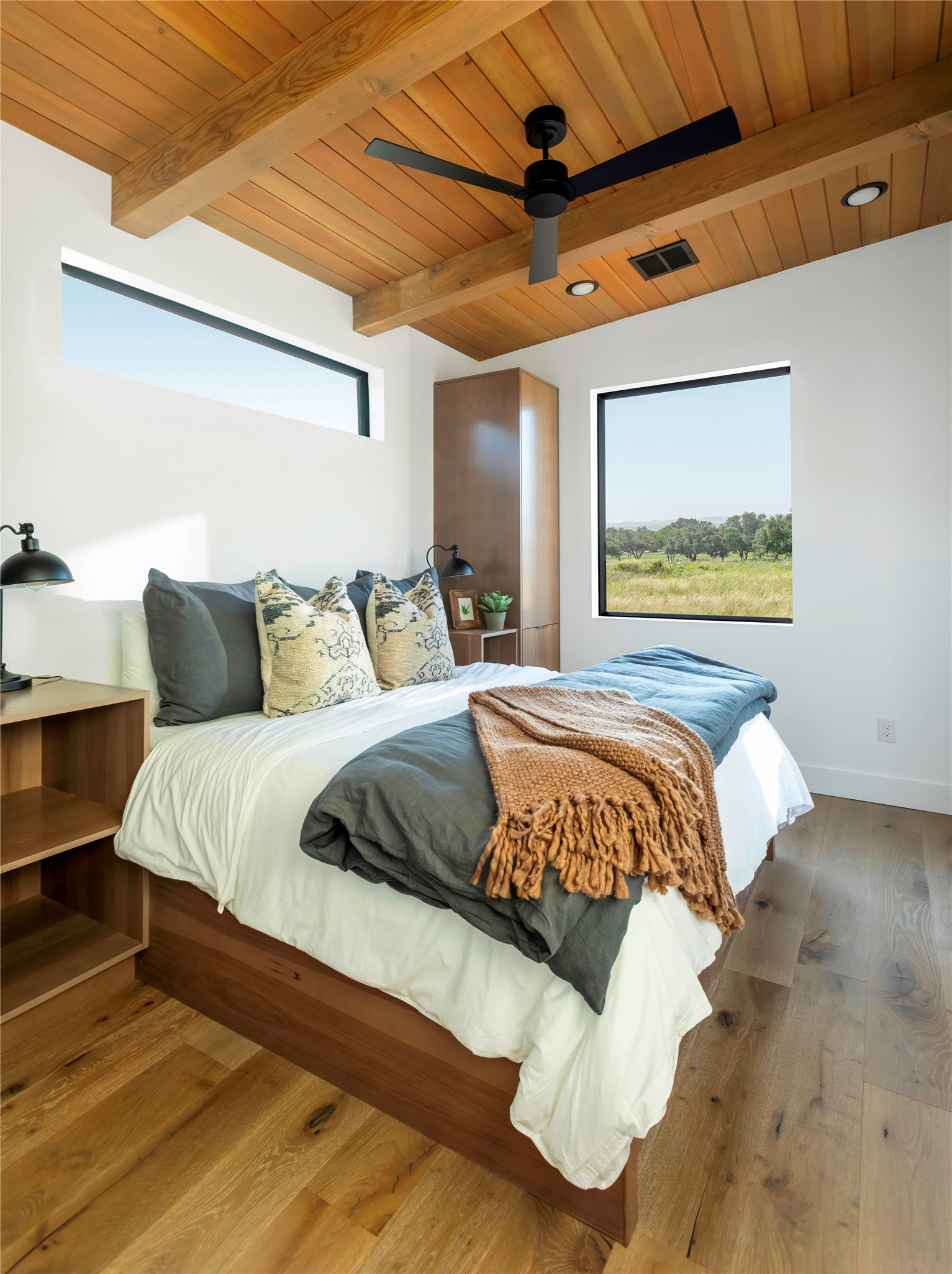 310 Hye Springs Road, Unit 107 Hye, TX 78635 - Photo 6 of 20 Serene master bedroom retreat with warm wood ceilings, large picture windows, and calming Hill Country views.