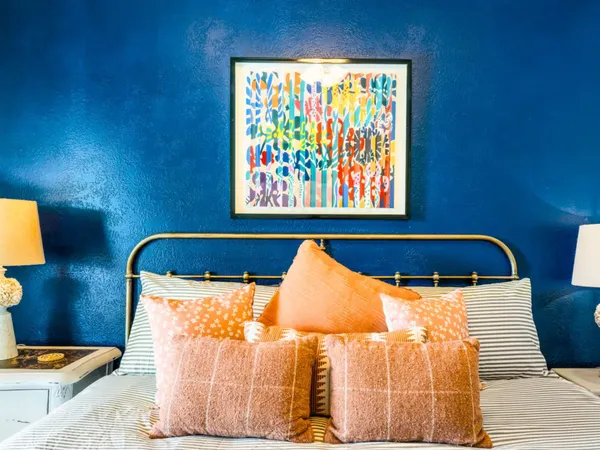 a bedroom with a bed and painting on the wall
