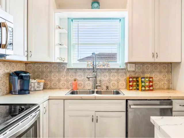 a kitchen with stainless steel appliances granite countertop a stove a refrigerator a kitchen island a table and chairs