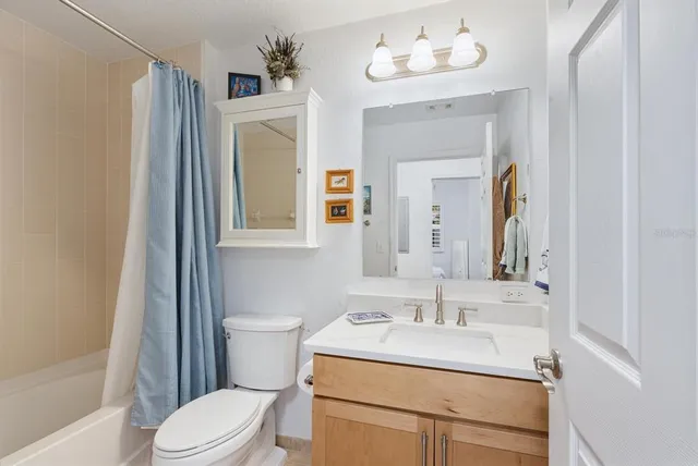 a bathroom with a sink vanity mirror and toilet