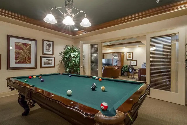 a room with pool table and windows