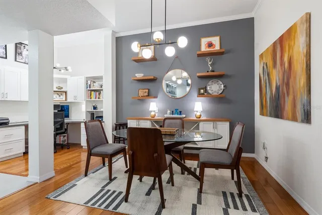 a view of a dining room and kitchen with furniture wooden floor and a clock