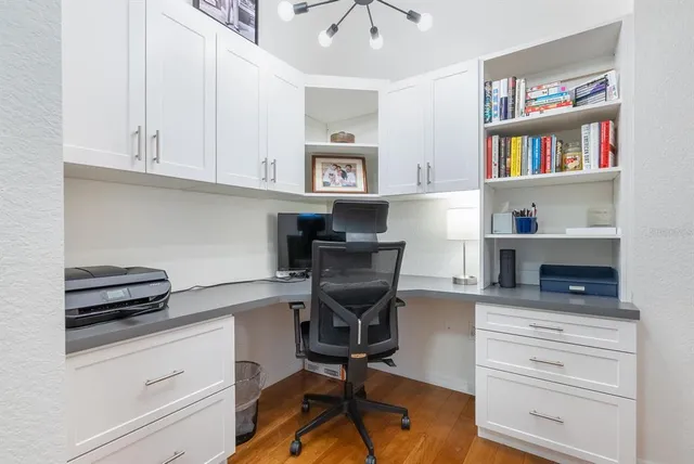 a view of a workspace with furniture and a window