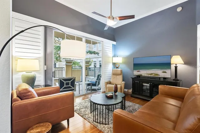 a living room with furniture a flat screen tv and a large window