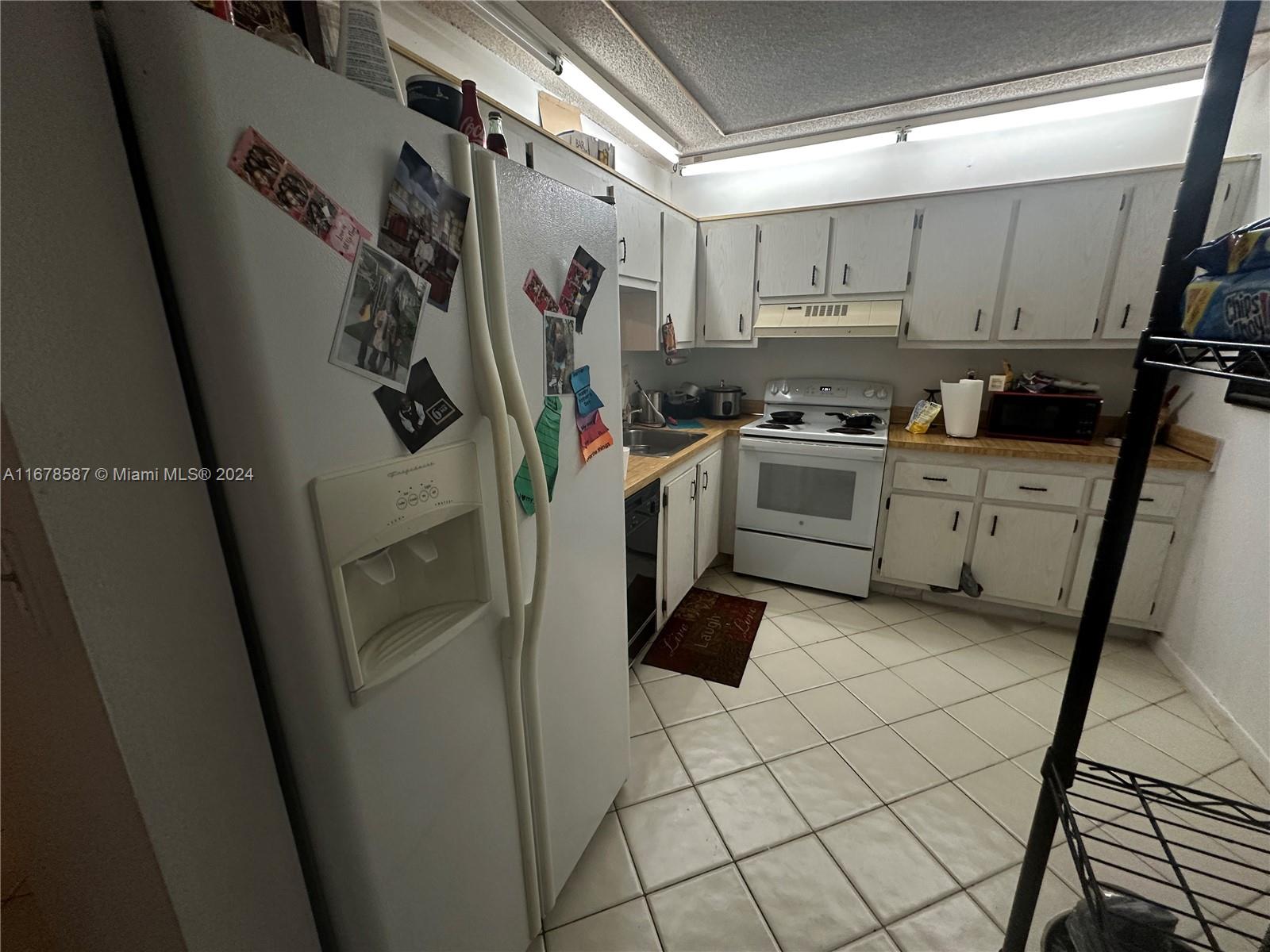 1820 Southwest 81st Avenue, Unit 3308 North Lauderdale, FL 33068 - Photo 19 of 49 a kitchen with a refrigerator and white cabinets