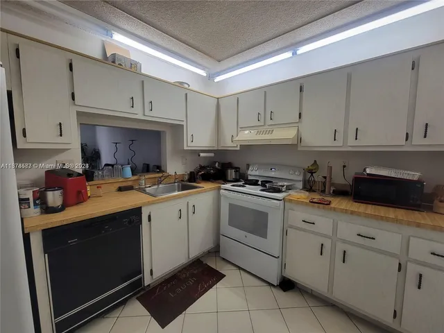 a kitchen with cabinets stainless steel appliances and a sink