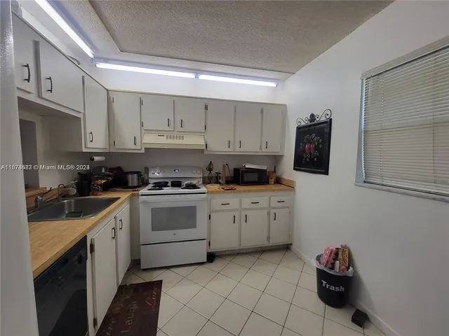a kitchen with cabinets stainless steel appliances and a sink