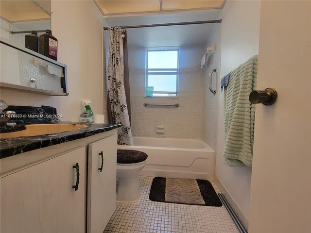 a bathroom with a sink a toilet a window and vanity