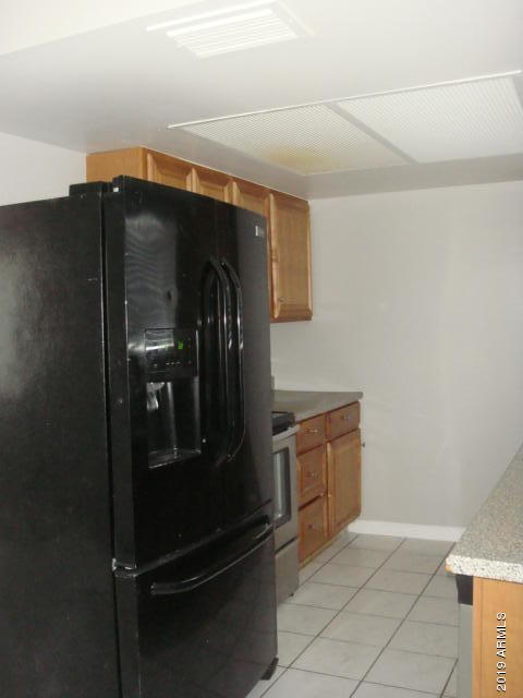 3315 West Loma Lane, Unit 4 Phoenix, AZ 85051 - Photo 11 of 13 a kitchen with white cabinets and stainless steel appliances