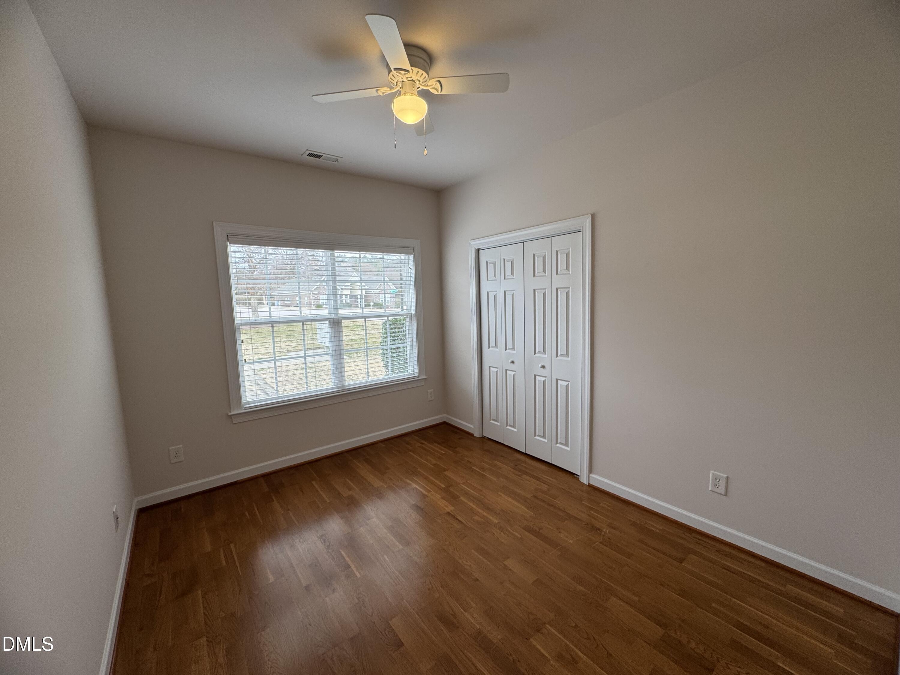 4622 Ivy Blossom Lane Raleigh, NC 27604 - Photo 12 of 15 an empty room with wooden floor fan and windows