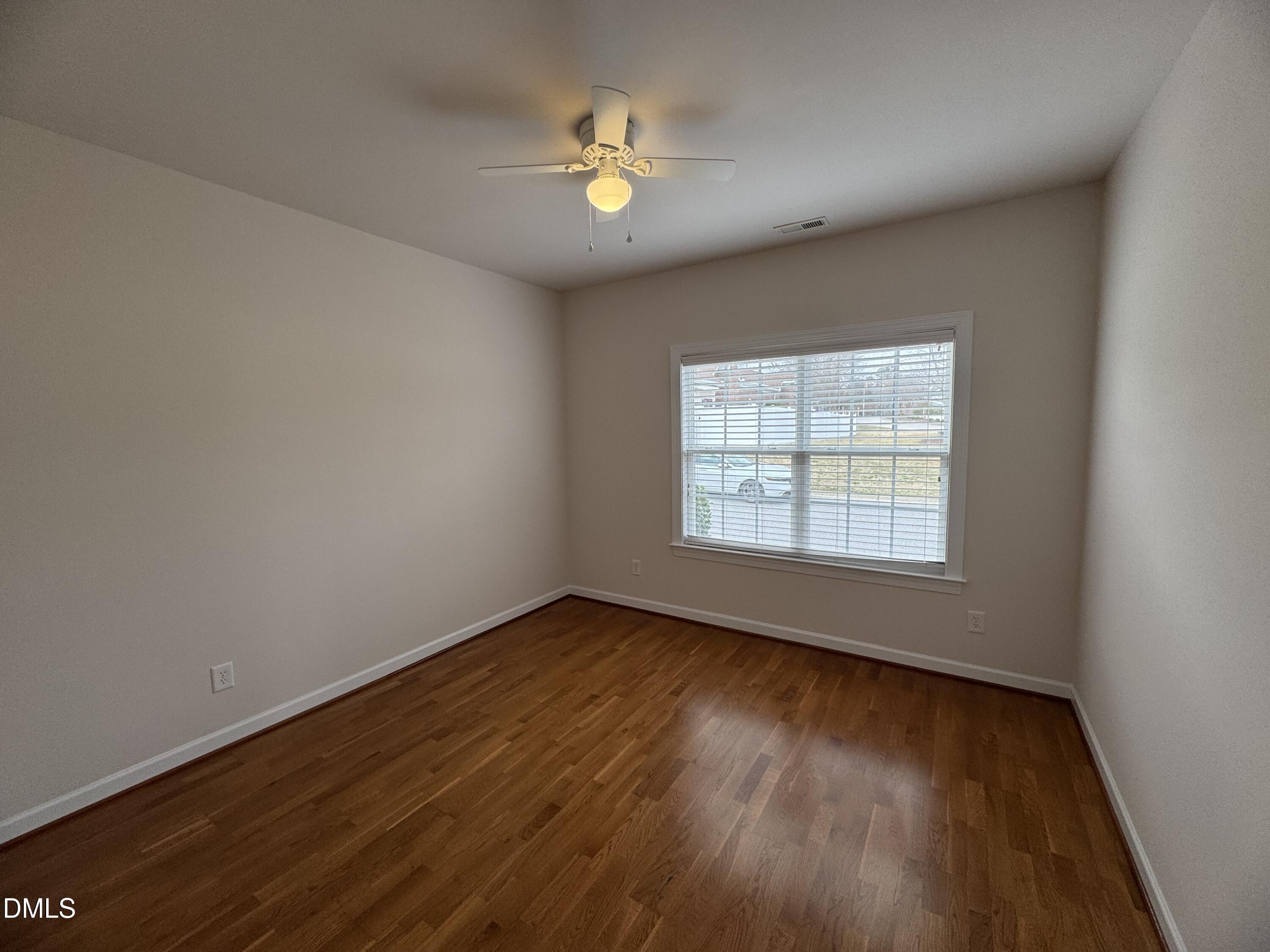 4622 Ivy Blossom Lane Raleigh, NC 27604 - Photo 13 of 15 an empty room with wooden floor and windows