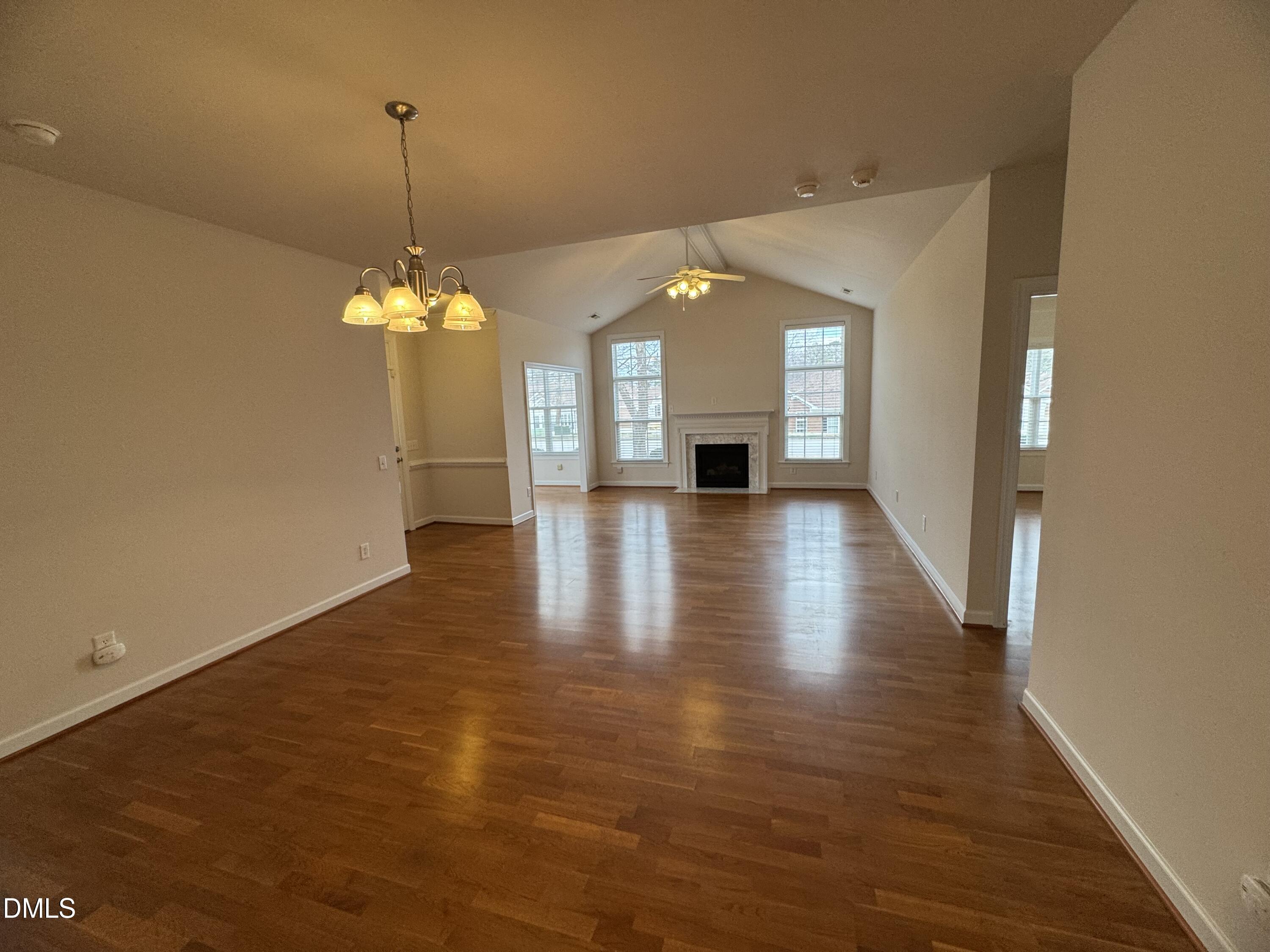 4622 Ivy Blossom Lane Raleigh, NC 27604 - Photo 3 of 15 an empty room with wooden floor fireplace and windows