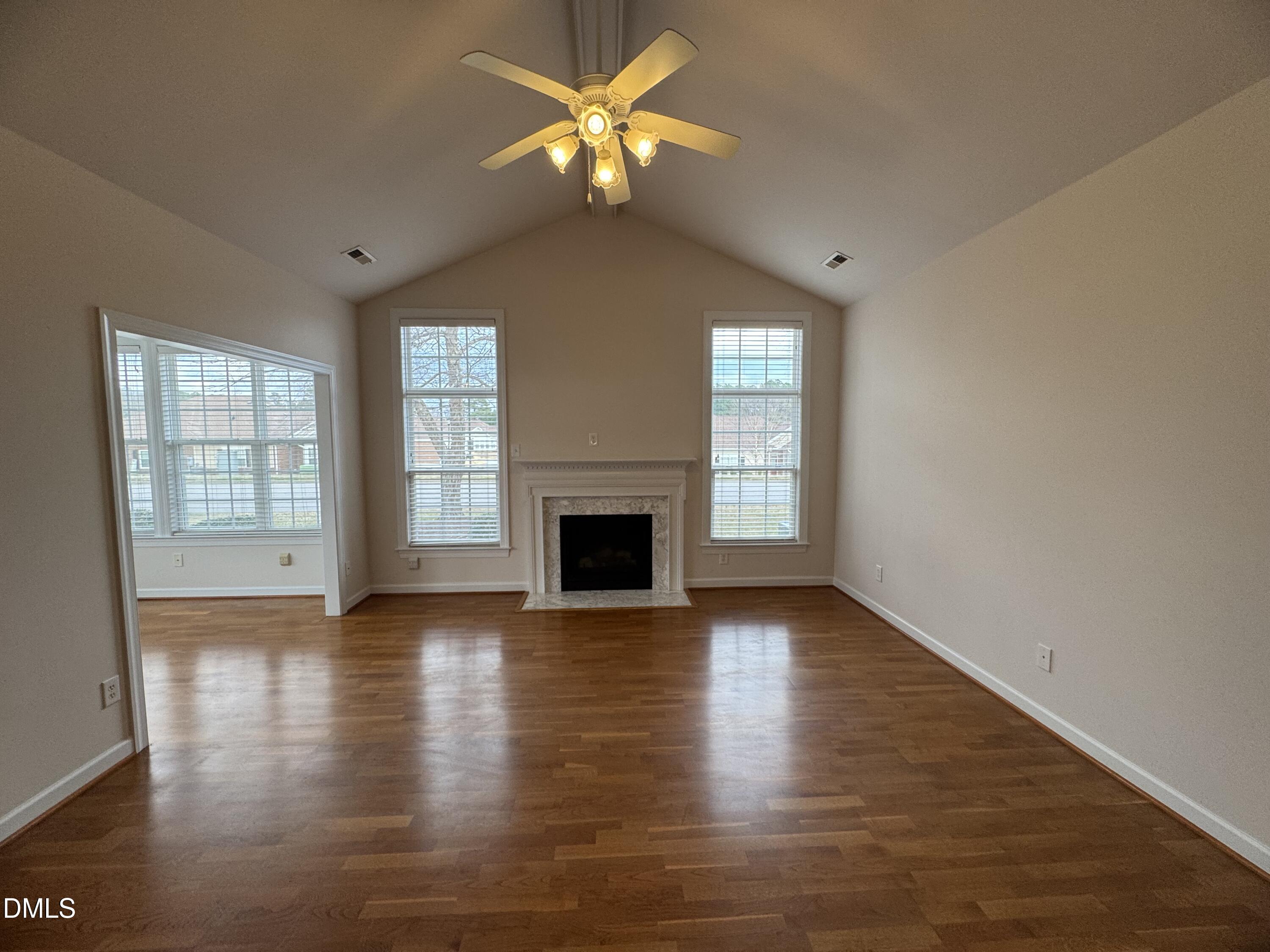 4622 Ivy Blossom Lane Raleigh, NC 27604 - Photo 6 of 15 an empty room with wooden floor fireplace and windows
