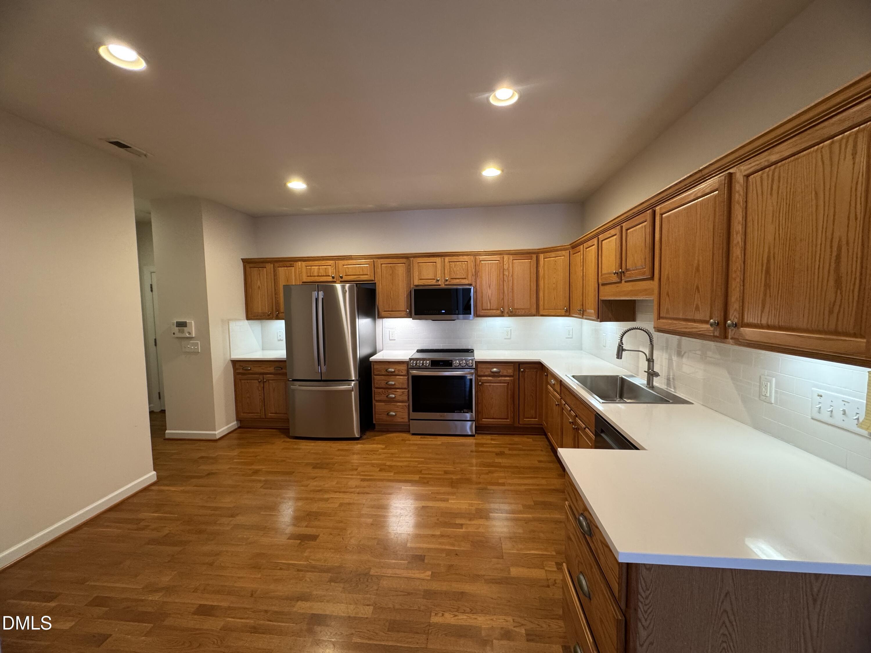 4622 Ivy Blossom Lane Raleigh, NC 27604 - Photo 7 of 15 a large kitchen with stainless steel appliances wooden cabinets a sink and a stove