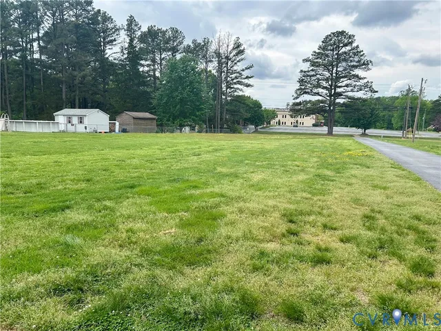 a view of garden with trees and buildings in the background