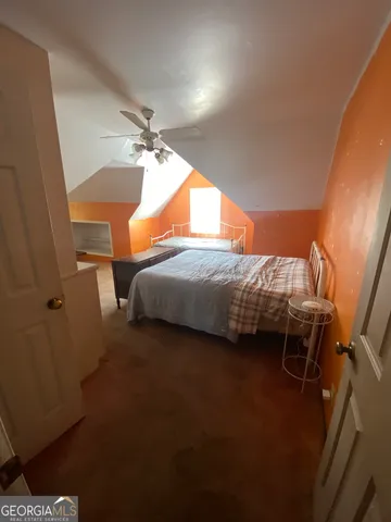 a backyard of a house with plants and large tree