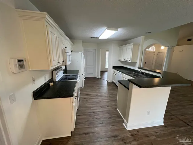 a kitchen with granite countertop a stove and a refrigerator