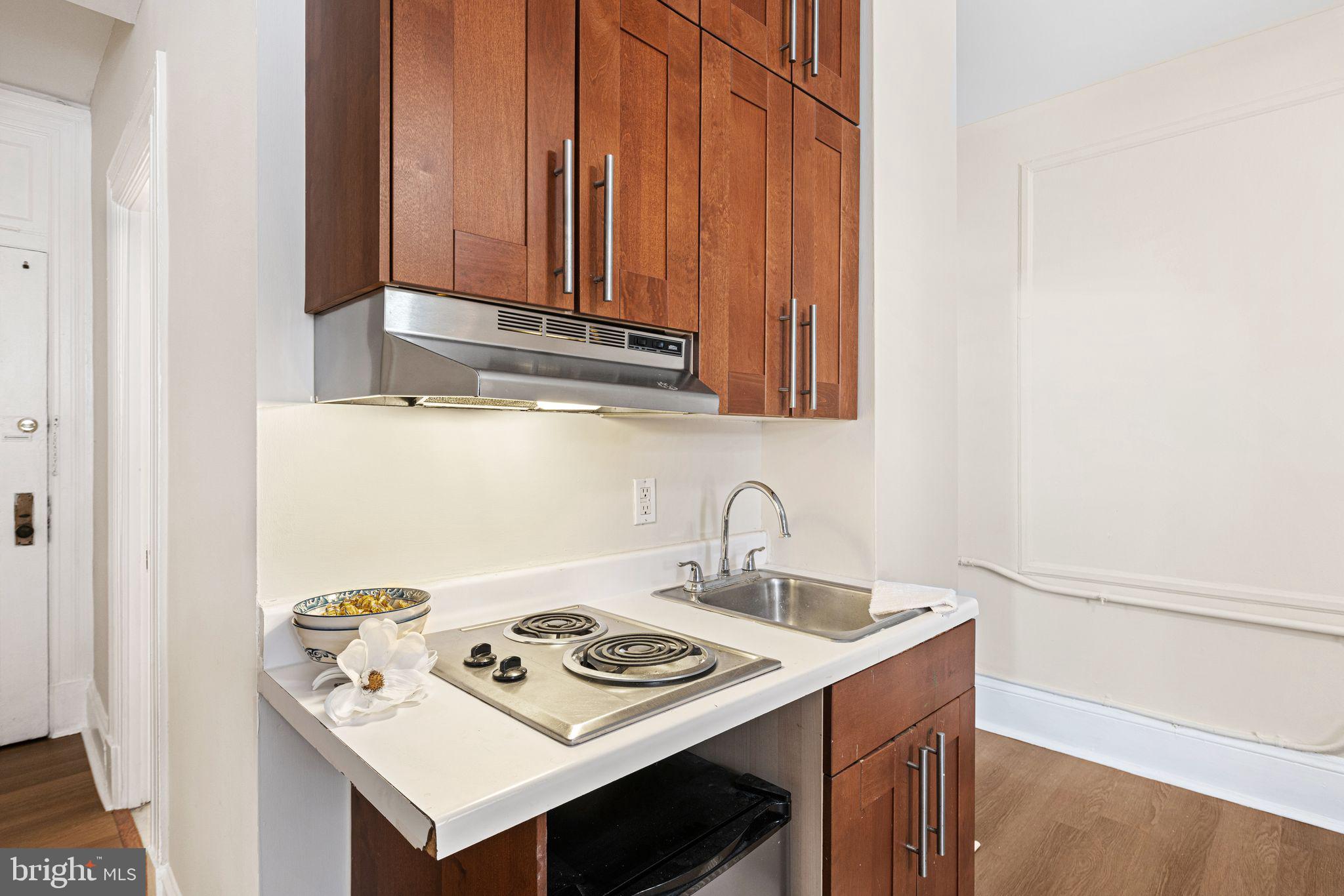 1324 Locust Street, Unit 717 Philadelphia, PA 19107 - Photo 4 of 12 a kitchen with a sink a stove and cabinets