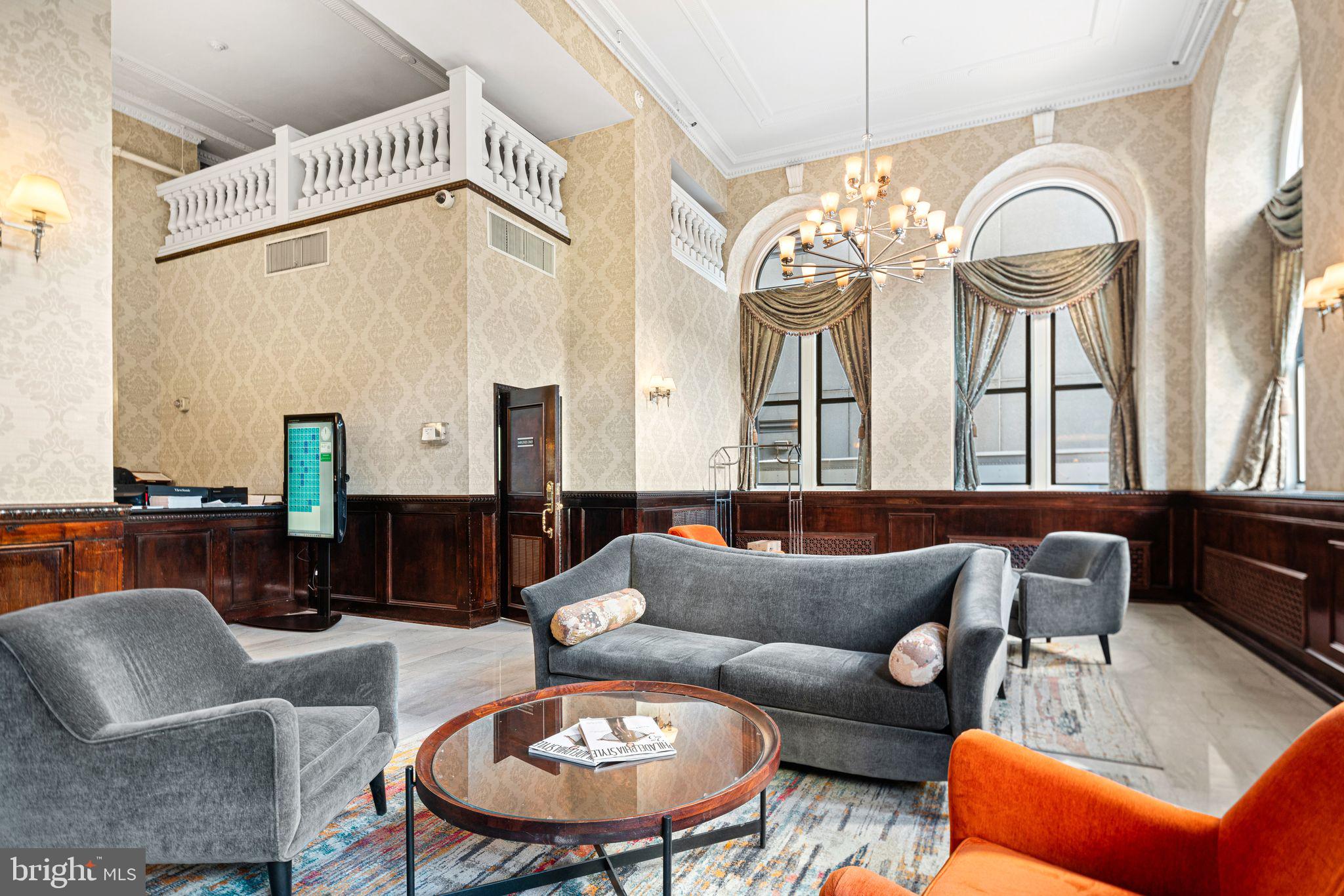 1324 Locust Street, Unit 717 Philadelphia, PA 19107 - Photo 8 of 12 a living room with furniture a fireplace and a chandelier