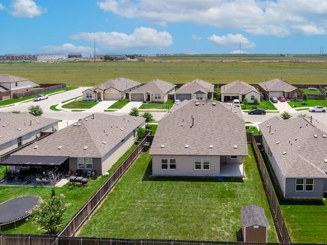 an aerial view of residential houses with outdoor space and ocean view