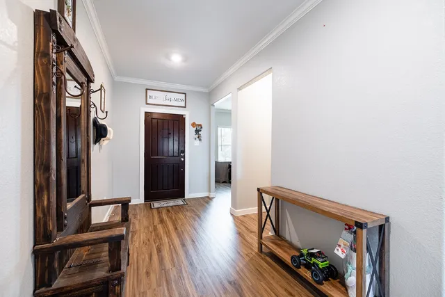 a view of a hallway with wooden floor and entryway