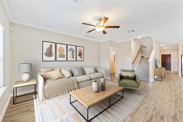 a living room with furniture and a wooden floor