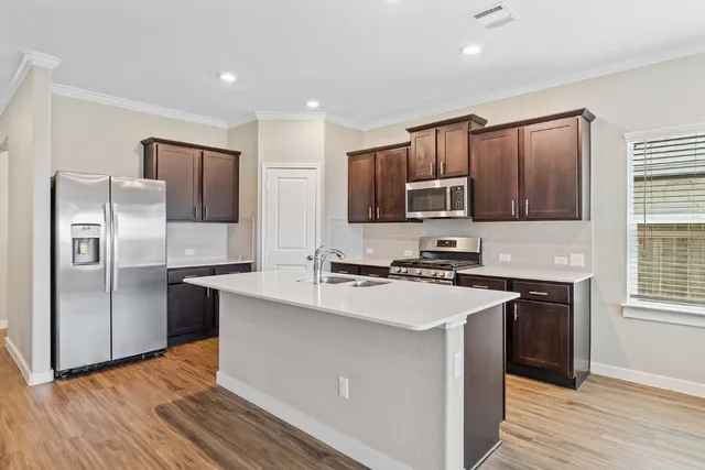 a kitchen with stainless steel appliances granite countertop a refrigerator stove microwave and sink