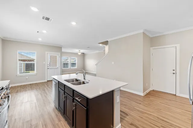 a kitchen with a sink stove and wooden floor