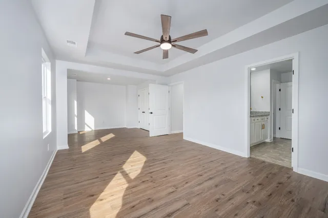a view of a room with wooden floor and ceiling fan