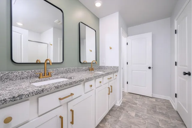a bathroom with double sink and a mirror