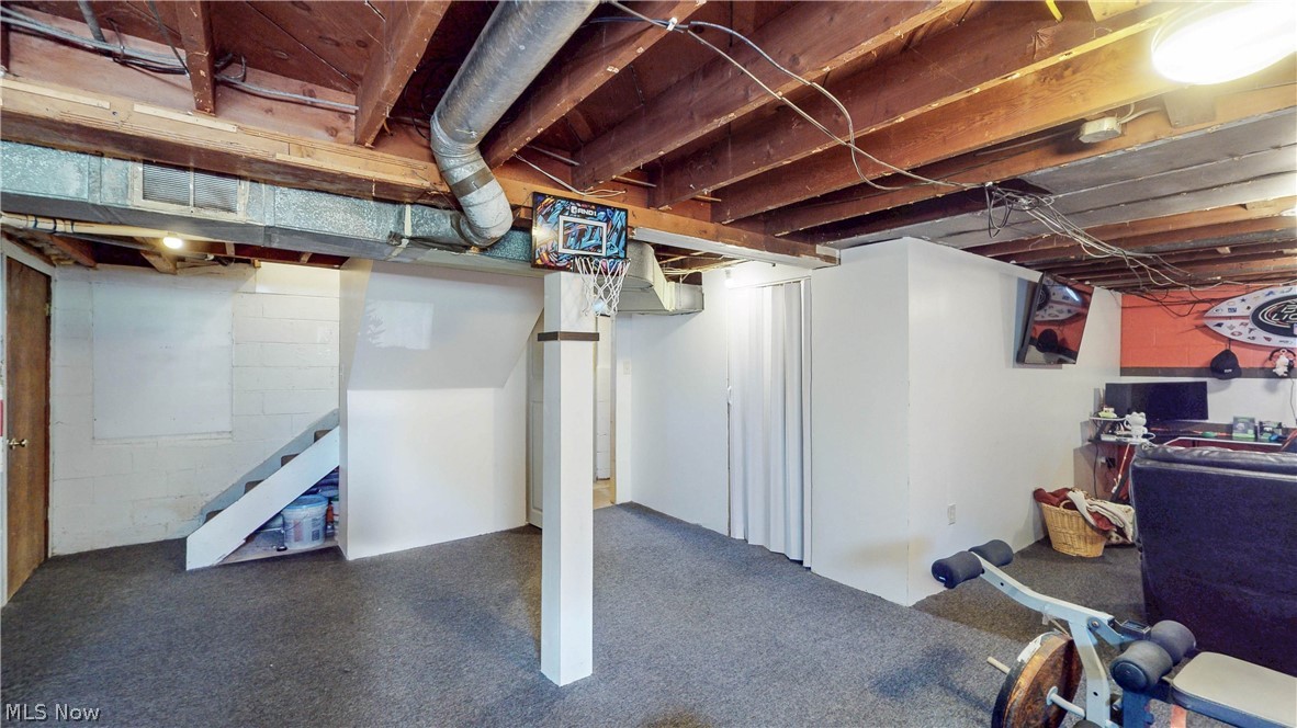 3659 Morrow Road Kent, OH 44240 - Photo 25 of 39 Finished basement space featuring exposed wood joists, structural columns, painted block walls, and carpet flooring