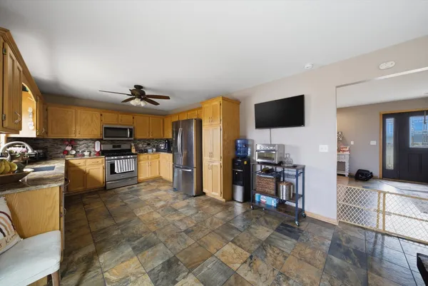 a kitchen with stainless steel appliances kitchen island granite countertop a refrigerator and a stove top oven