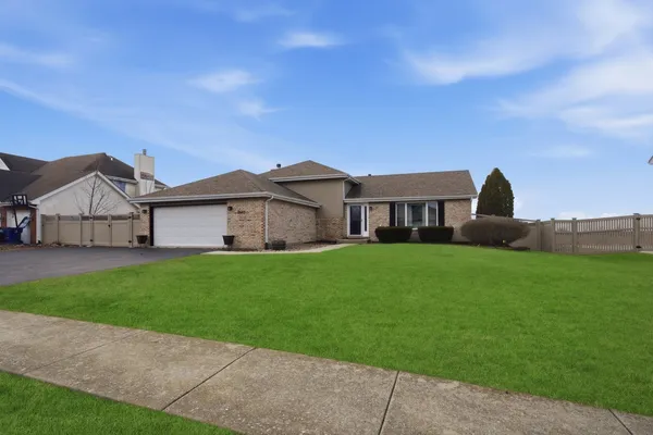 a view of a house with a big yard plants and large trees