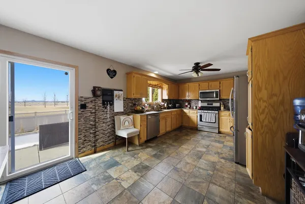 a kitchen with stainless steel appliances kitchen island granite countertop a refrigerator and cabinets