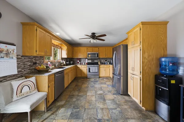 a large kitchen with stainless steel appliances granite countertop a stove refrigerator and a sink
