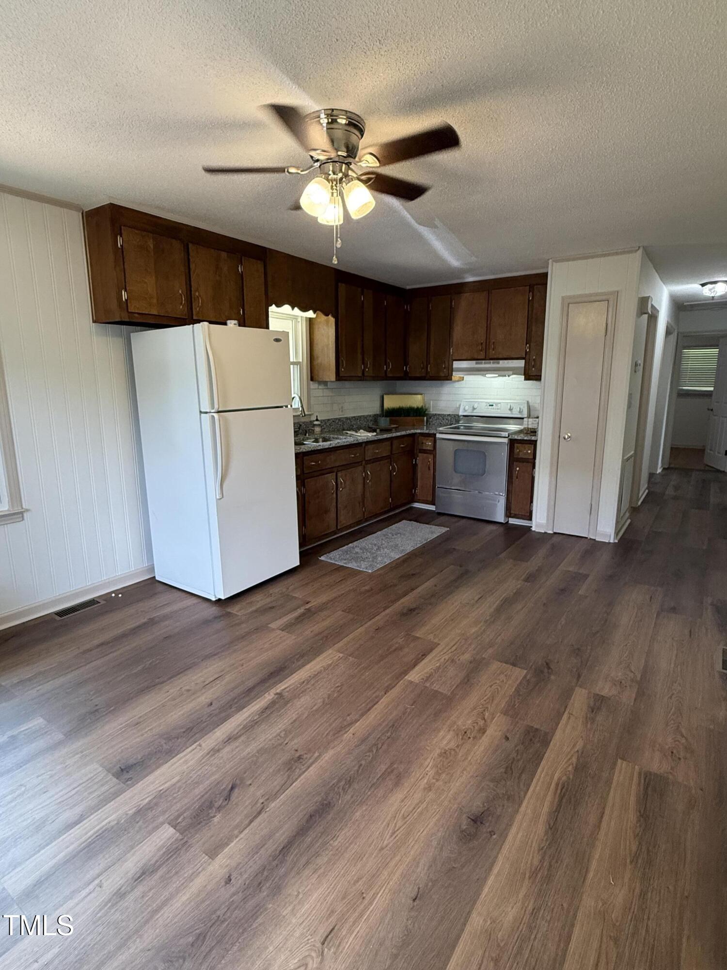 404 West A Street Erwin, NC 28339 - Photo 13 of 44 a kitchen with stainless steel appliances wooden floor and a refrigerator