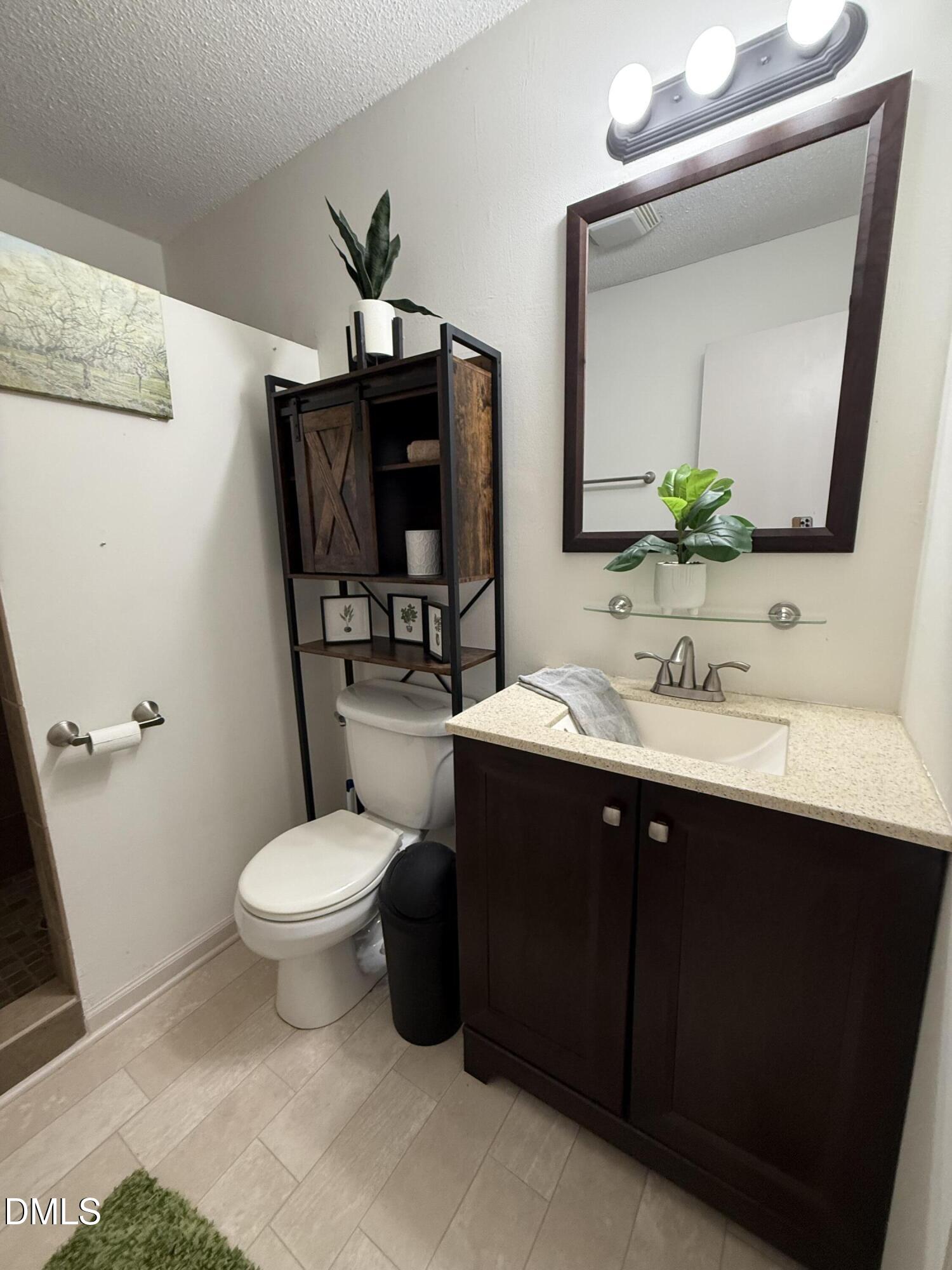 404 West A Street Erwin, NC 28339 - Photo 18 of 44 a bathroom with a sink toilet and mirror