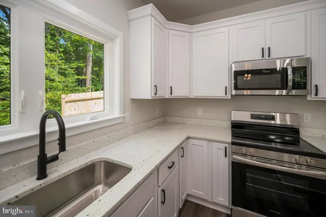 a kitchen with granite countertop a sink and a stove top oven