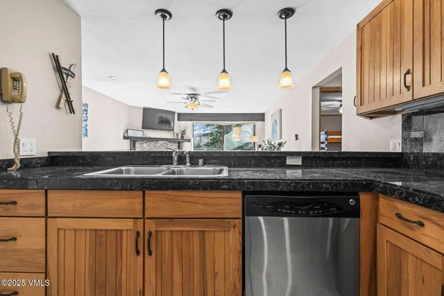 a kitchen with stainless steel appliances granite countertop a sink a stove and a wooden cabinets