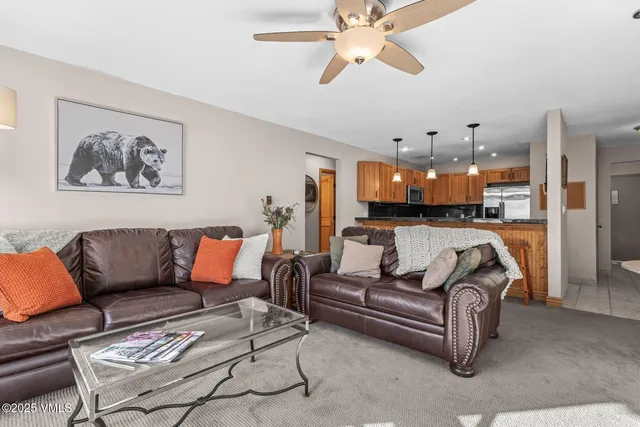 a living room with furniture and kitchen view