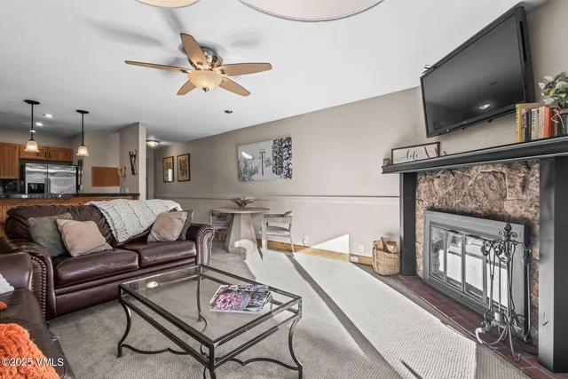 a living room with furniture a flat screen tv and kitchen view