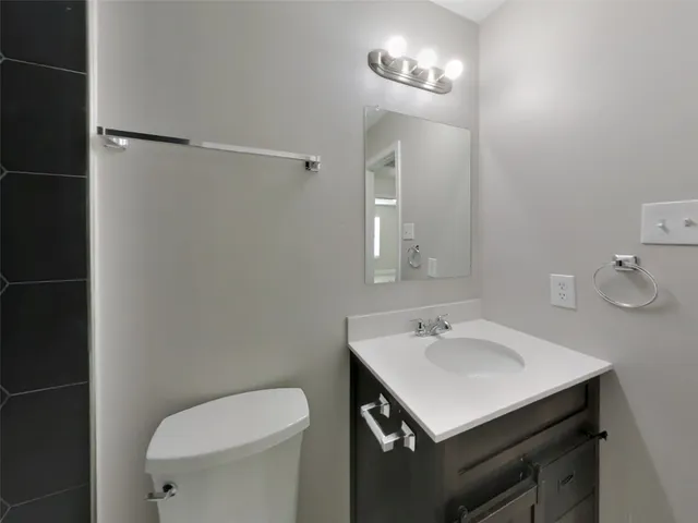 a bathroom with a sink toilet and a mirror
