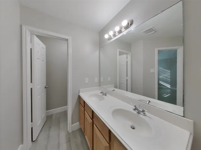 a bathroom with a double vanity sink and a mirror