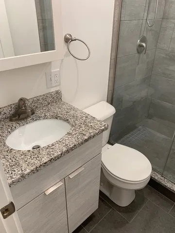 a bathroom with a shower a toilet and a sink