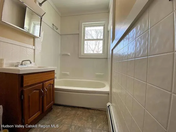a bathroom with a bathtub sink vanity and mirror