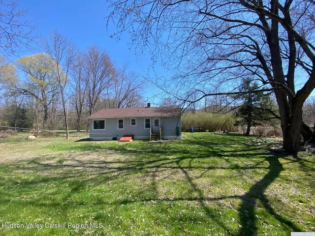 a view of a big house with a big yard and large tree