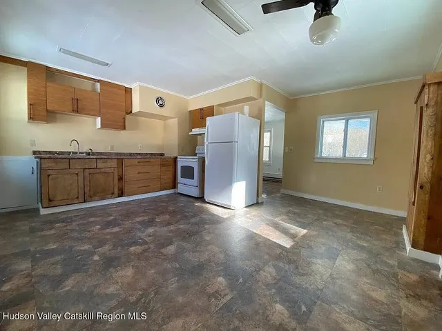 a large kitchen with stainless steel appliances granite countertop a refrigerator and a stove top oven